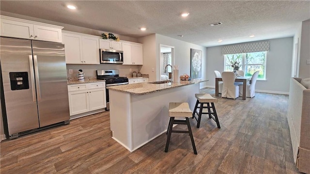 kitchen featuring white cabinetry, appliances with stainless steel finishes, and a kitchen island with sink