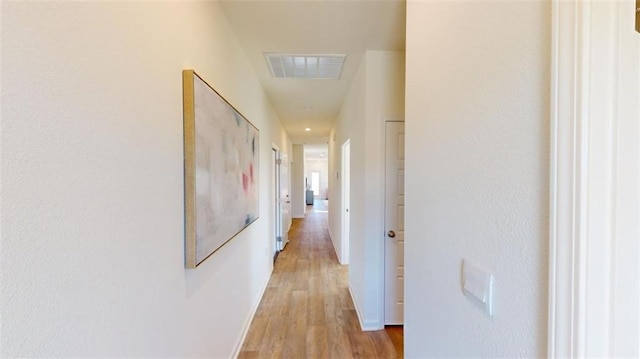 hallway with light hardwood / wood-style floors