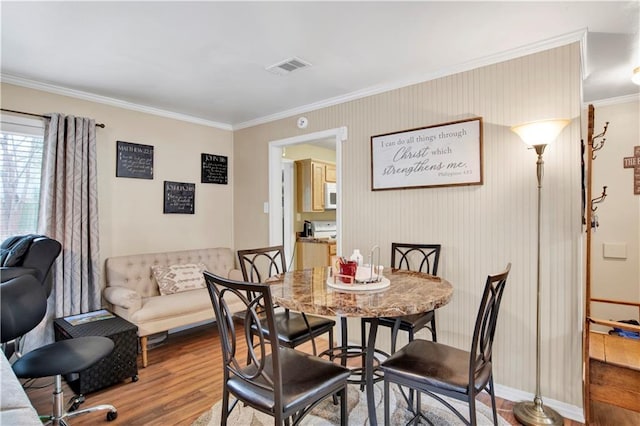 dining space featuring crown molding and hardwood / wood-style flooring