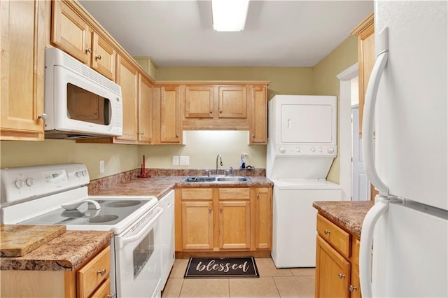 kitchen with sink, white appliances, light tile patterned floors, and stacked washer / dryer