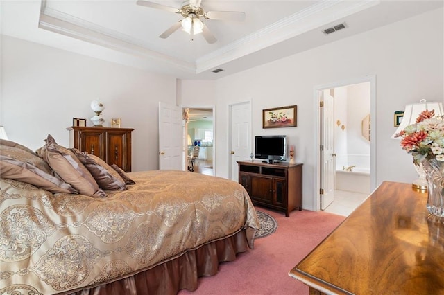 carpeted bedroom with ornamental molding, a raised ceiling, ceiling fan, and ensuite bathroom