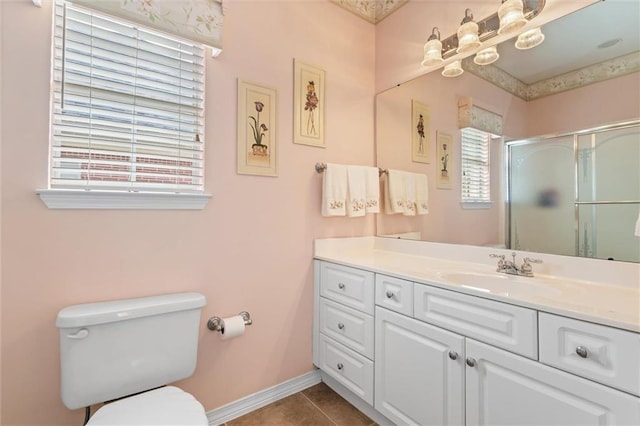 bathroom featuring tile patterned flooring, vanity, a shower with shower door, and toilet