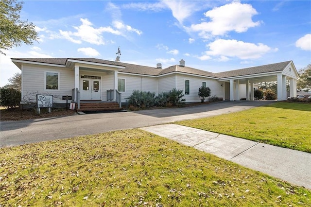 ranch-style house featuring a carport, a front yard, and french doors