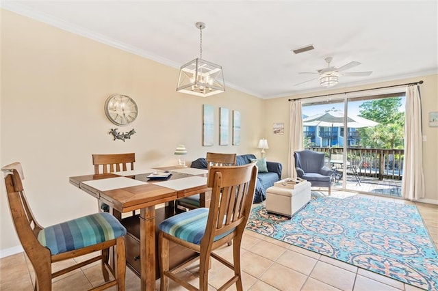 tiled dining room with ceiling fan and crown molding