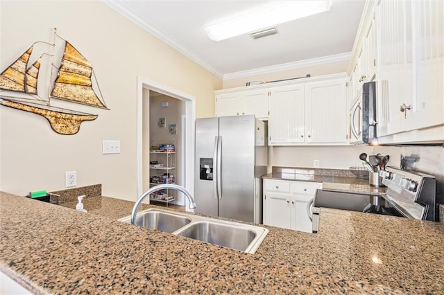 kitchen with kitchen peninsula, appliances with stainless steel finishes, ornamental molding, sink, and white cabinets