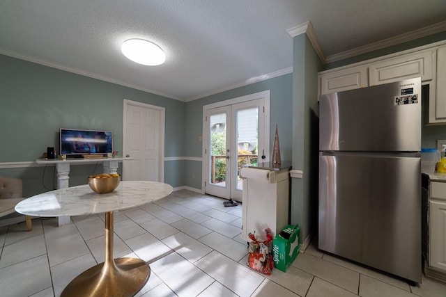 kitchen with white cabinets, stainless steel fridge, french doors, and ornamental molding