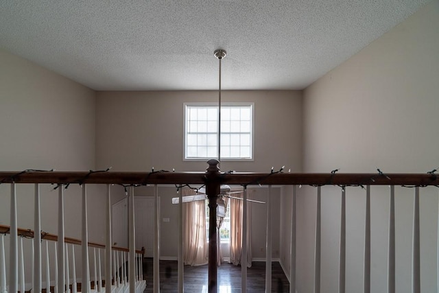 details with a textured ceiling and hardwood / wood-style flooring