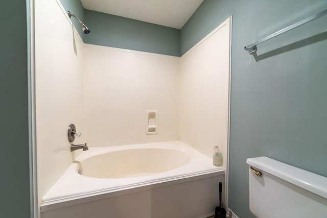 bathroom with bathtub / shower combination and toilet