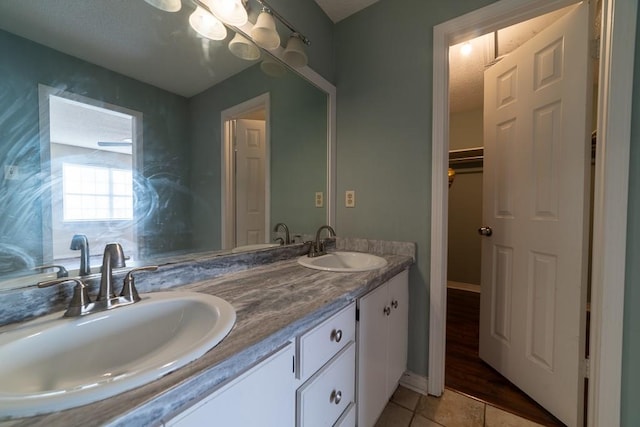 bathroom with a textured ceiling, vanity, and tile patterned floors