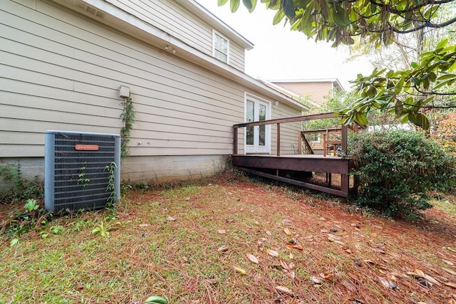 view of side of property featuring central air condition unit and a wooden deck