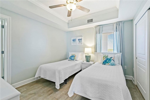 bedroom featuring crown molding, ceiling fan, a closet, and wood-type flooring