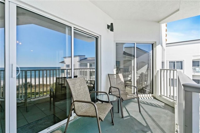 balcony with a water view and a beach view