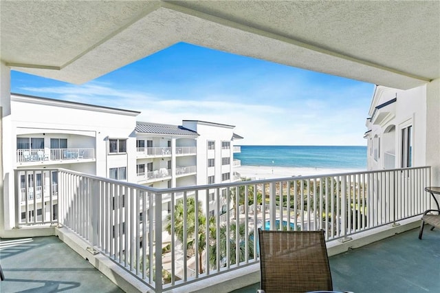 balcony with a water view and a beach view