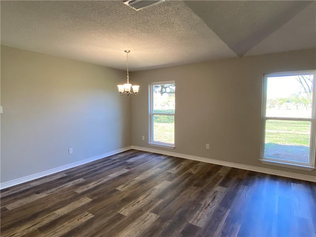 unfurnished room featuring a notable chandelier, dark wood finished floors, visible vents, a textured ceiling, and baseboards