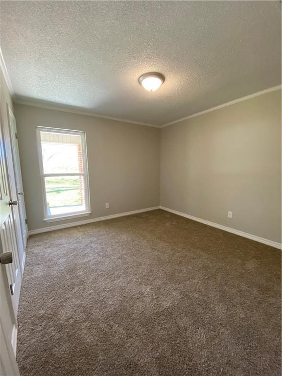 empty room featuring baseboards, a textured ceiling, dark carpet, and crown molding