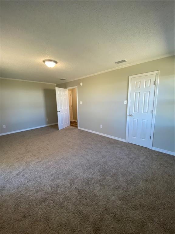 unfurnished bedroom featuring baseboards, ornamental molding, a textured ceiling, and carpet flooring