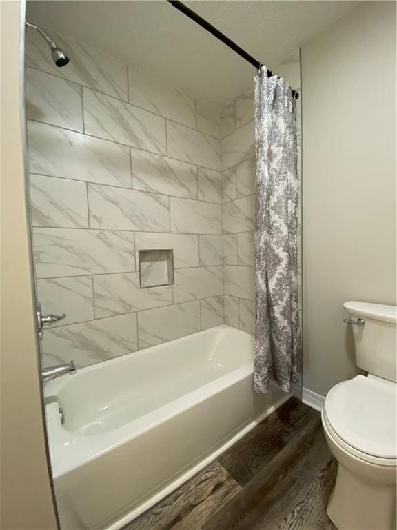 full bathroom with toilet, shower / bathtub combination with curtain, baseboards, and wood finished floors