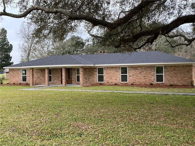 single story home featuring a shingled roof, a front lawn, and brick siding