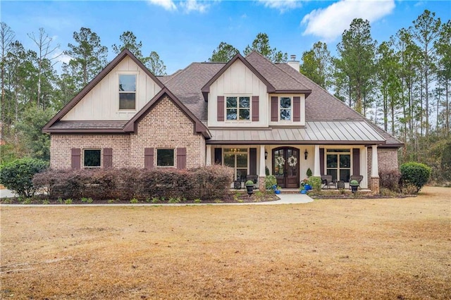 craftsman house featuring covered porch and a front lawn