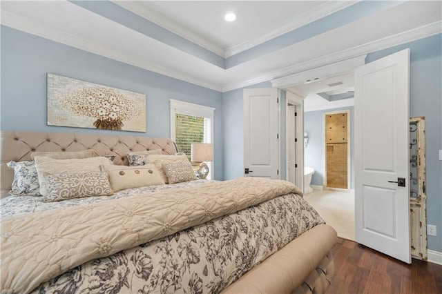 bedroom featuring ornamental molding, dark hardwood / wood-style floors, and a tray ceiling