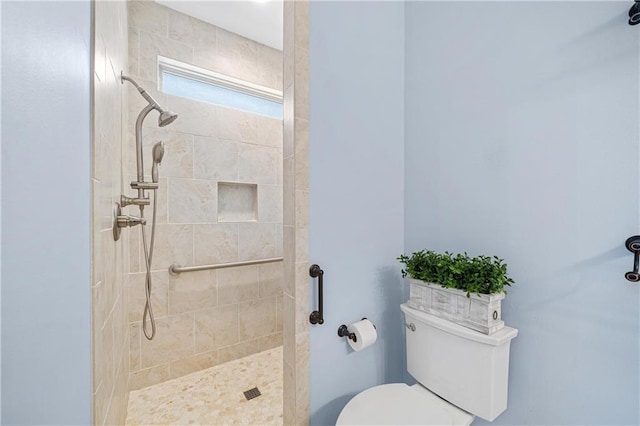 bathroom featuring toilet and a tile shower