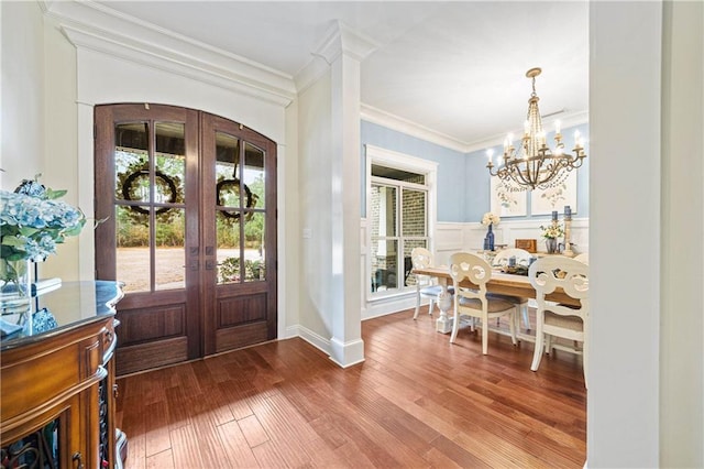 entryway featuring crown molding, french doors, a chandelier, and hardwood / wood-style flooring