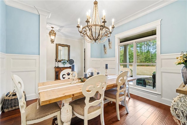 dining space with dark hardwood / wood-style flooring, crown molding, and a chandelier