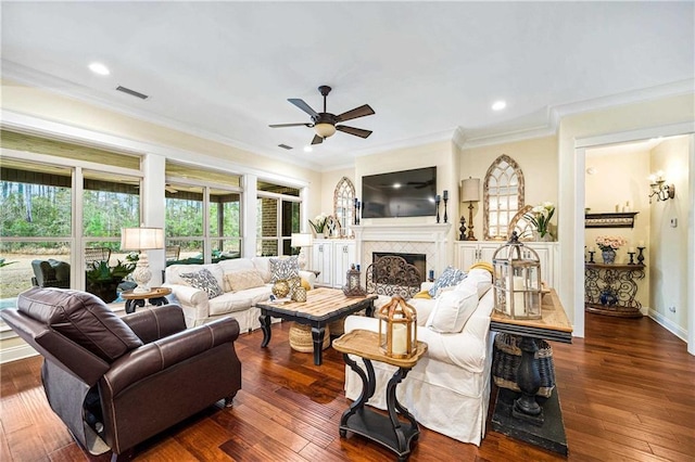 living room featuring dark wood-type flooring, ornamental molding, and ceiling fan