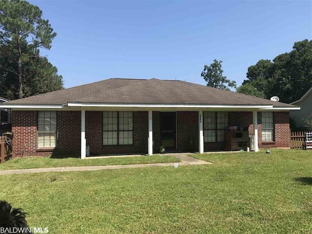 rear view of property featuring a lawn