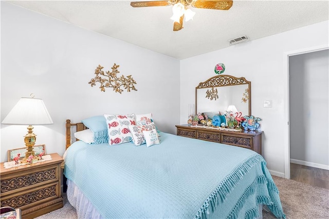 carpeted bedroom featuring a textured ceiling and ceiling fan