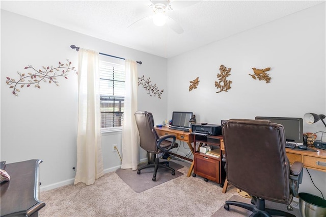 carpeted office space featuring ceiling fan