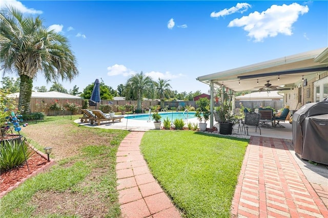 view of yard with a fenced in pool, ceiling fan, and a patio area