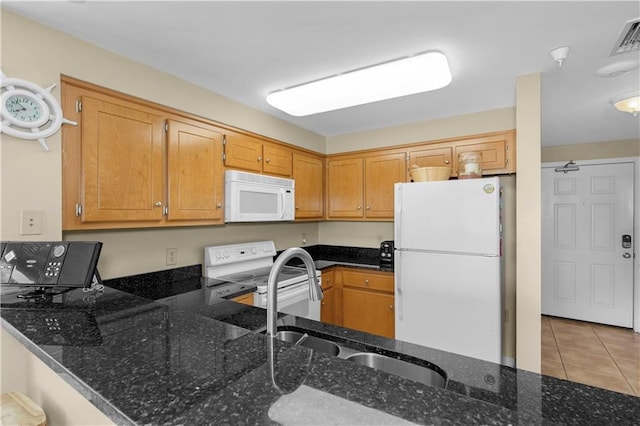 1801 Bienville Blvd Unit 213, Dauphin Island, AL 36528 - kitchen featuring white appliances, a sink, dark stone counters, light tile patterned floors, and a peninsula