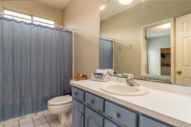 bathroom with toilet, vanity with extensive cabinet space, and tile flooring