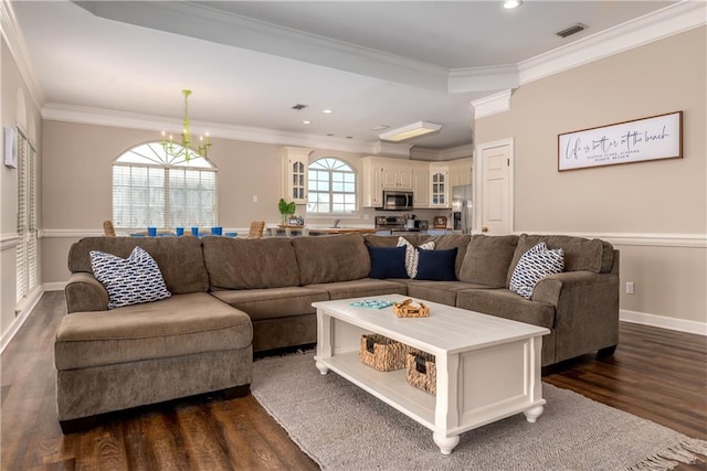 living room featuring crown molding, a notable chandelier, and dark hardwood / wood-style flooring