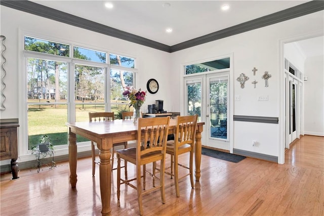 dining space featuring crown molding, french doors, plenty of natural light, and light wood finished floors