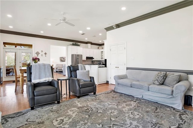 living area featuring crown molding, recessed lighting, ceiling fan, and light wood-style flooring