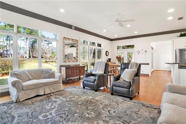 living area featuring recessed lighting, visible vents, baseboards, light wood-style floors, and crown molding