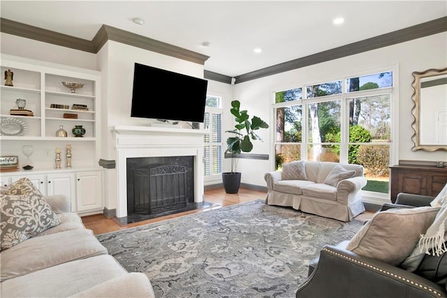 living room featuring light wood finished floors, a healthy amount of sunlight, a fireplace, and crown molding