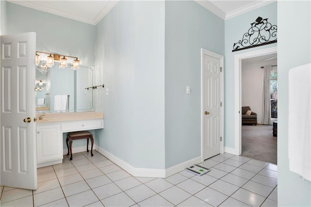 bathroom with tile patterned flooring, crown molding, vanity, and baseboards