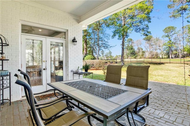 view of patio with outdoor dining area, fence, and french doors