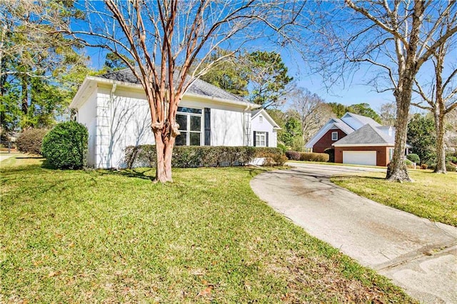 ranch-style house with a garage, a front lawn, and stucco siding