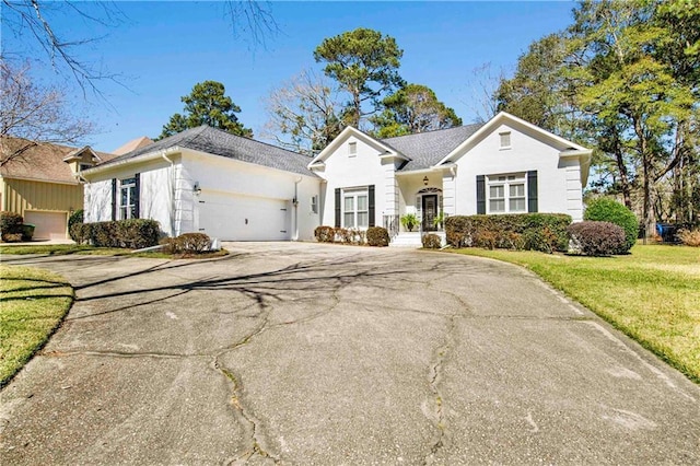 view of front facade featuring a front lawn, driveway, and an attached garage