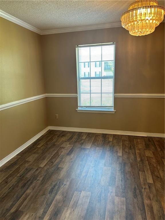 spare room featuring a notable chandelier, dark hardwood / wood-style flooring, a textured ceiling, and crown molding