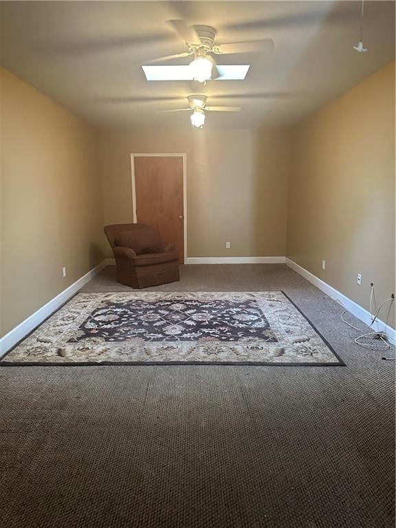 unfurnished room with carpet floors, ceiling fan, and a skylight