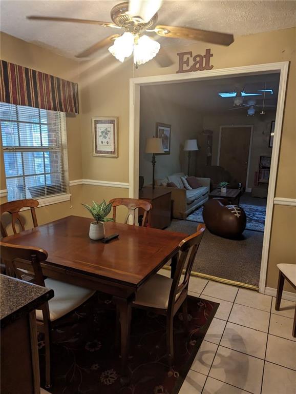 tiled dining room with ceiling fan