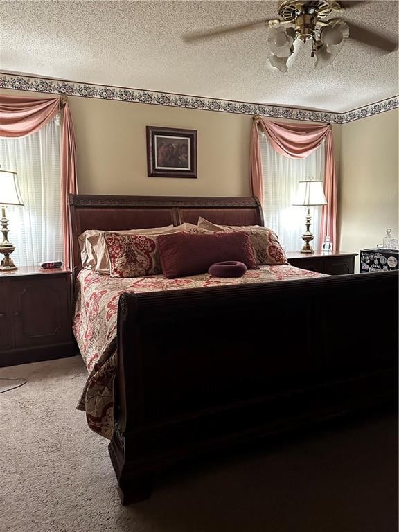 carpeted bedroom featuring a textured ceiling and ceiling fan