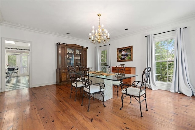 dining space with a chandelier, a healthy amount of sunlight, ornamental molding, and light wood-type flooring