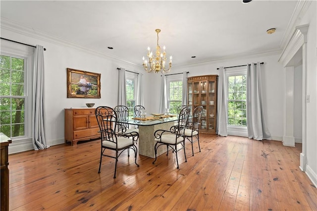 dining space featuring ornamental molding, an inviting chandelier, light hardwood / wood-style floors, and a wealth of natural light