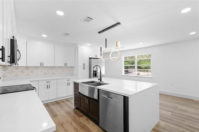 3158 Lees Ln, Mobile, AL 36693 - kitchen with visible vents, a sink, light countertops, appliances with stainless steel finishes, and light wood finished floors